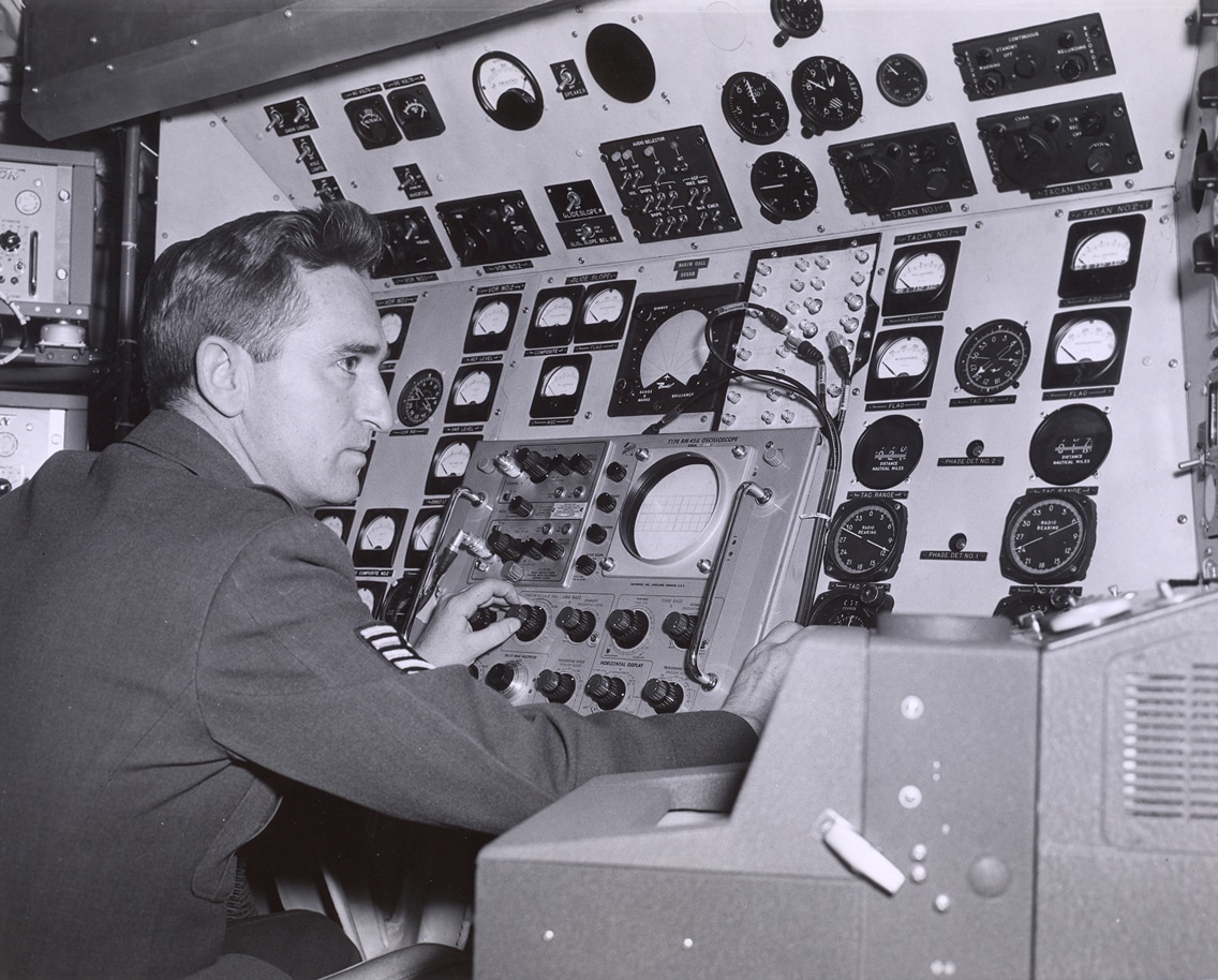 A technician checks the test console inside an Air Force Communications Service C-140A.